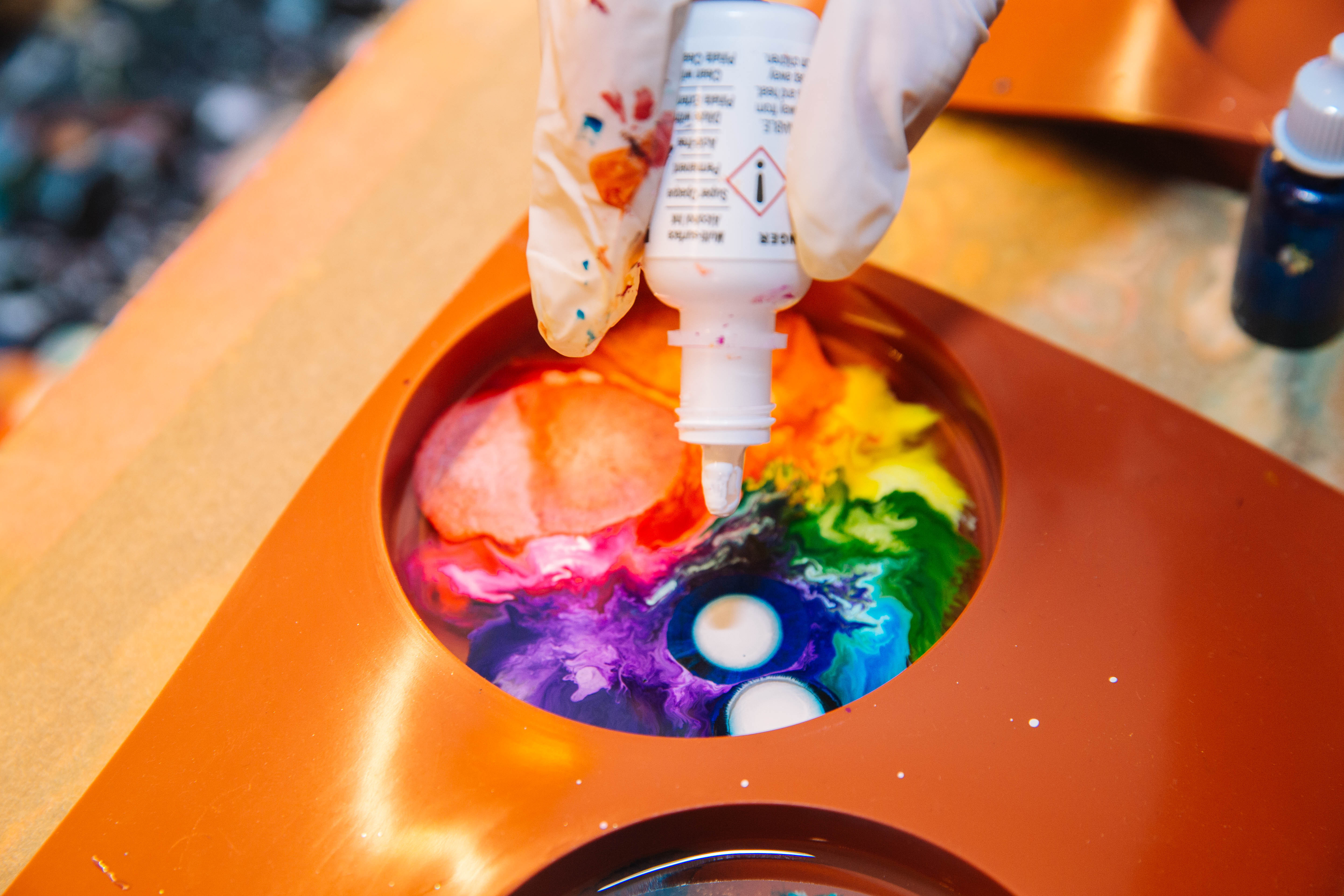 Handing adding drops to an alcohol ink artwork